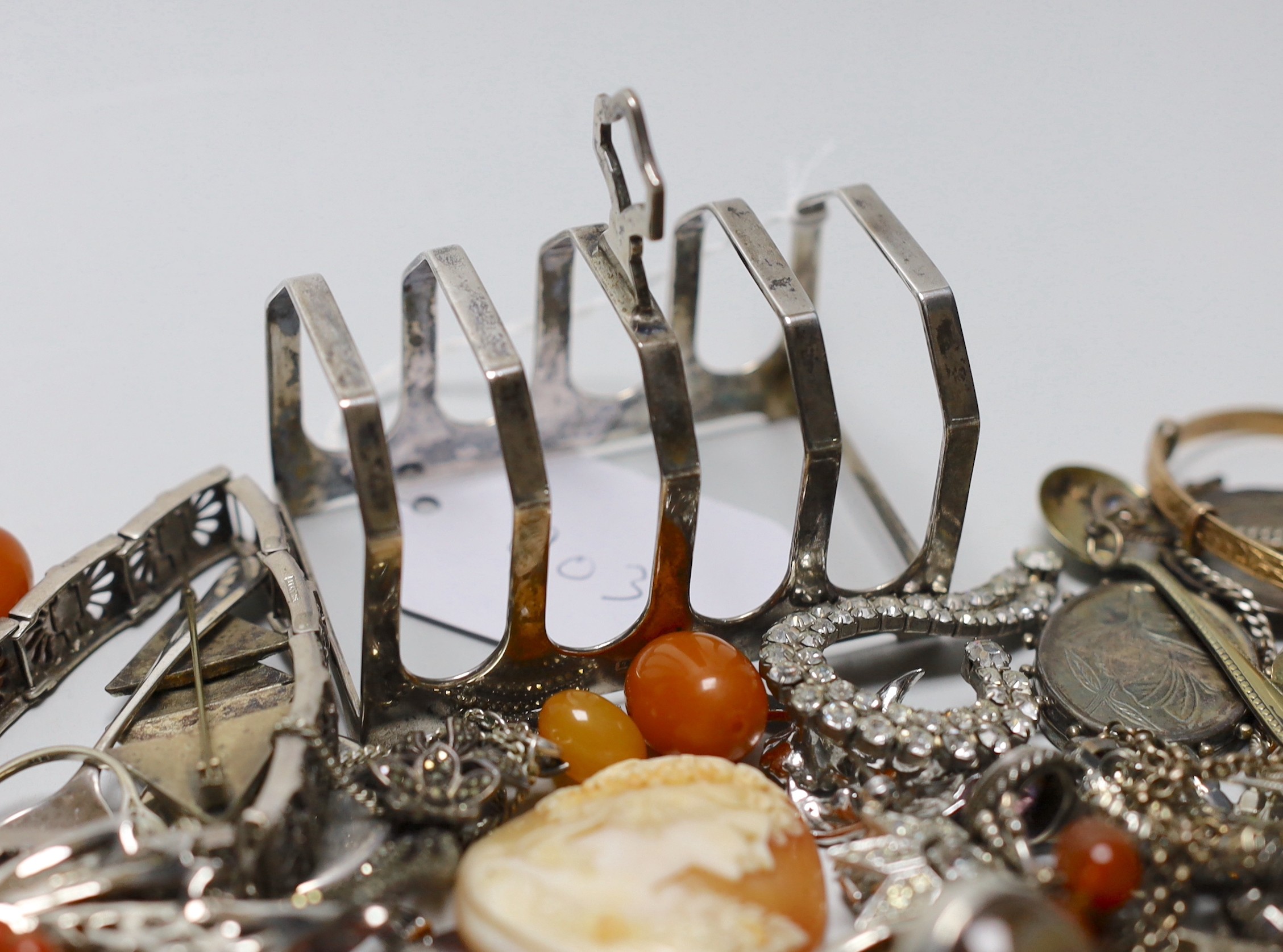 Mixed costume jewellery including a silver, marcasite and moonstone set flower brooch, faux amber beads, etc. and a silver five bar toast rack.